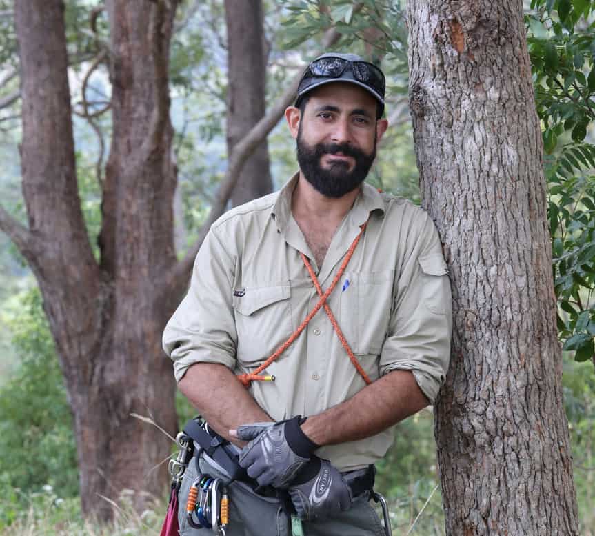 George Madani leaning against a tree