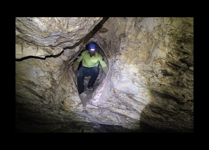 Caver with headlamp in Dennings Labyrinth, Wombeyan Karst Conservation Reserve