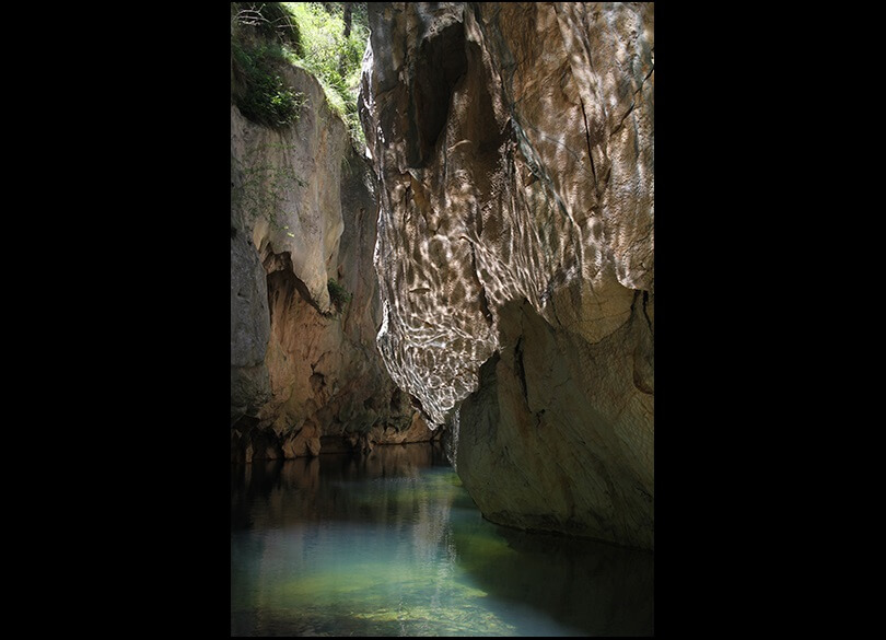 River at the bottom of a narrow gorge with reflections from the water on the rock gorge walls. Mares Forest wilderness Wombeyan Caves