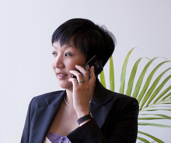 A woman wearing a blazer talking on a mobile phone