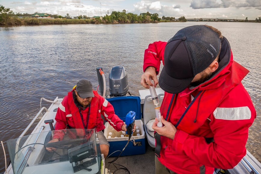 Staff test water in a boat on the Hunter River