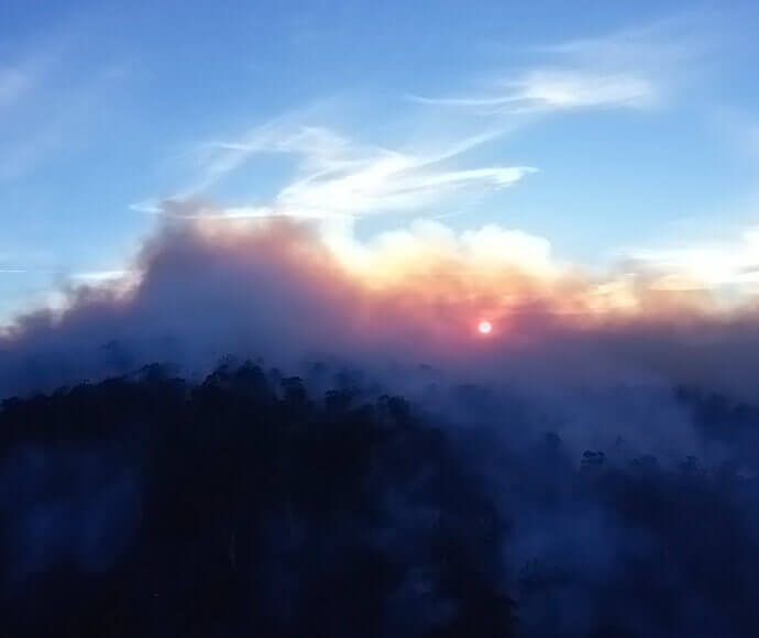 Smoke at sunrise with clouds and early morning mist viewed from helicopter. Denison Providence hazard reduction burn