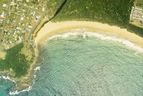 A view of Black Head Lagoon separating the Black Head village centre and sand dunes behind the beach