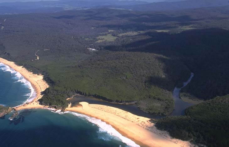 A view of Bournda Lagoon surrounded by Bournda National Park and Bournda Beach in the foreground