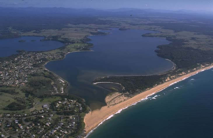 A view of Coila Lake next to the seaside village of Tuross Head and Bingle Beach in the foreground