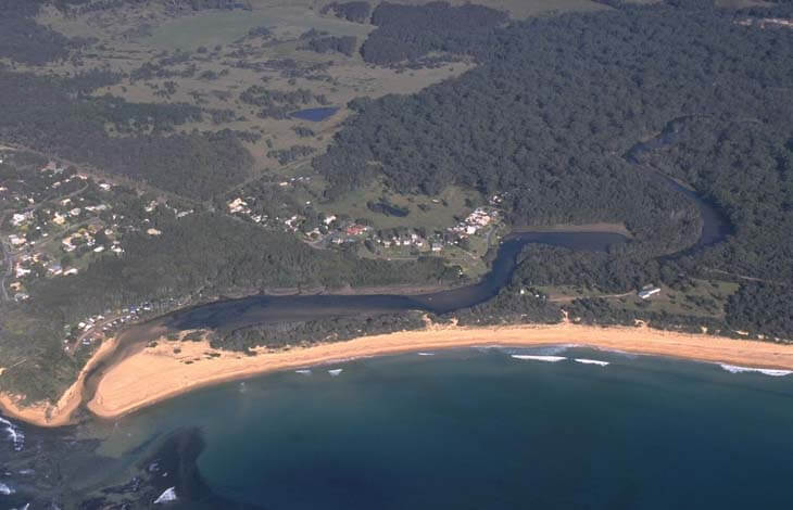 A view of Congo Creek meeting the sea next to the village of Congo with the beach in the foreground