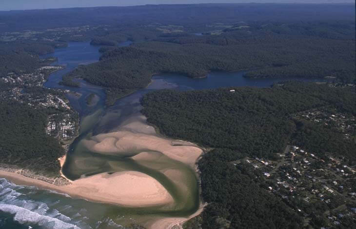 A view of Conjola Lake meeting the sea next to the town of Lake Conjola and Conjola Beach in the foreground