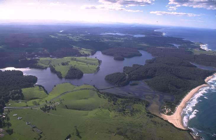 A view of Corunna Lake surrounded by rolling green hills and Loader Beach