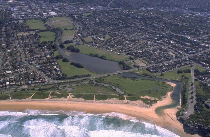 A view of Curl Curl Lagoon with the Sydney suburb of North Curl Curl in the background and North Curl Curl Beach in the foreground