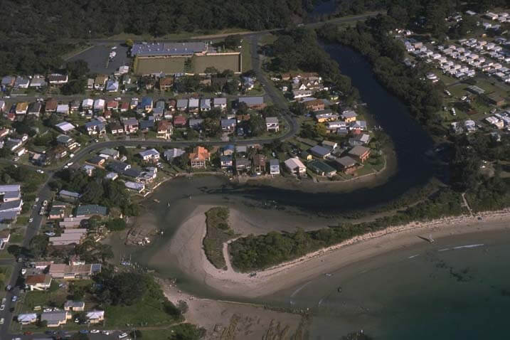 A view of Currarong Creek with the town of Currarong in the background and Currarong Beach in the foreground