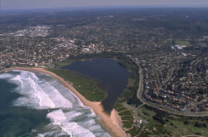 A view of Dee Why Lagoon surrounded by the Sydney suburb of Dee Why and Dee Why Beach in the foreground