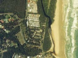 A view of Duchess Gully meeting the sea surrounded by Rainbow Beach and the town of Bonny Hills