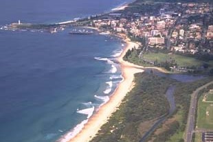 A view of Fairy Creek meeting the sea surrounded by Wollongong with Fairy Meadow Beach in the foreground