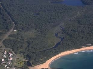 Aerial view showing a lake connected to the ocean by a small, winding creek