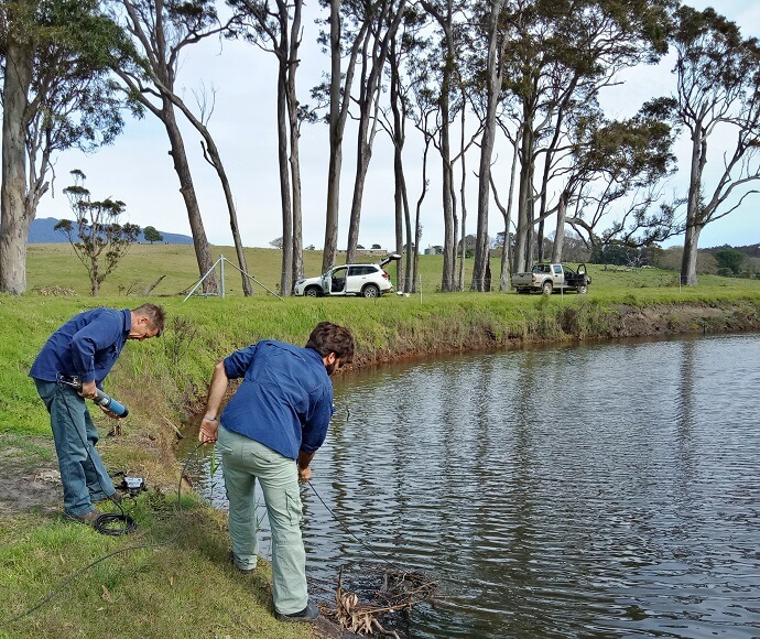  Two people on the banks of Tilba Tilba Lake taking water samples