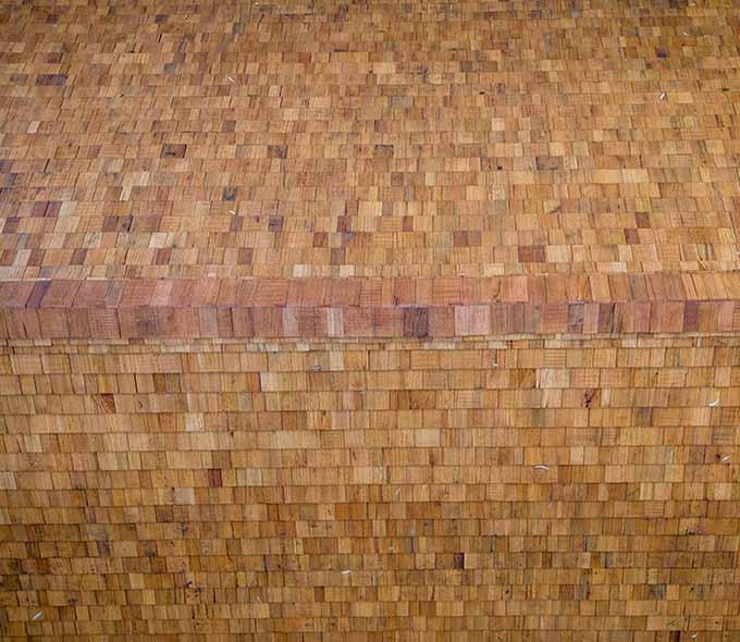 A close-up view of a roof with an intricate pattern of interlocking wooden tiles