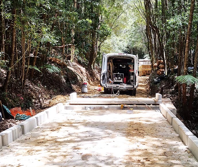 A new bridge under construction at Dorrigo National Park, with scaffolding and construction materials visible, showing the progress of the bridge taking shape over a forested area.