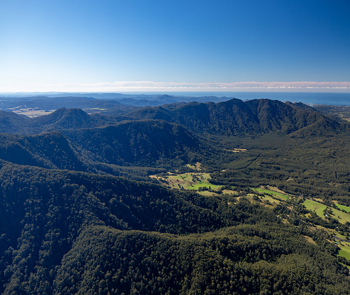 View over green valley surrounded by forested hills