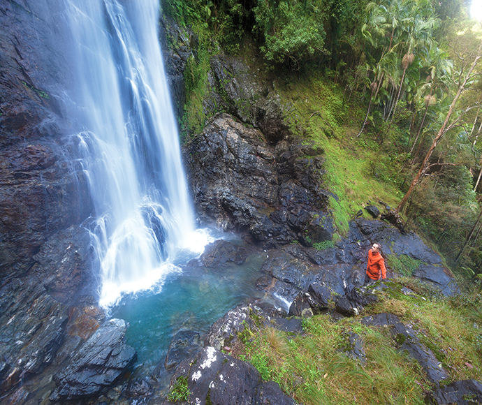 Base of large waterfall with person standing close by