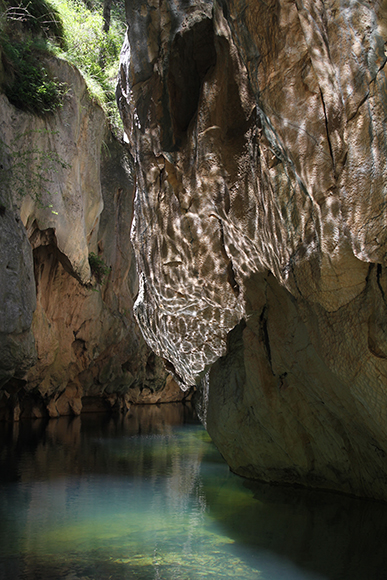 River at the bottom of a narrow gorge with reflections from the water on the rock gorge walls. Mares Forest wilderness Wombeyan Caves