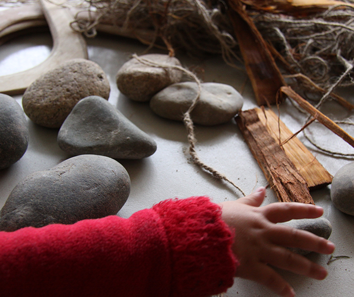 A display table with assorted Aboriginal crafts arranged for a children’s discovery workshop. The crafts include items decorated with traditional patterns and natural materials, showcasing Aboriginal artistry and cultural significance. This setup highlights the importance of hands-on activities in teaching children about Aboriginal heritage and cultural practices.