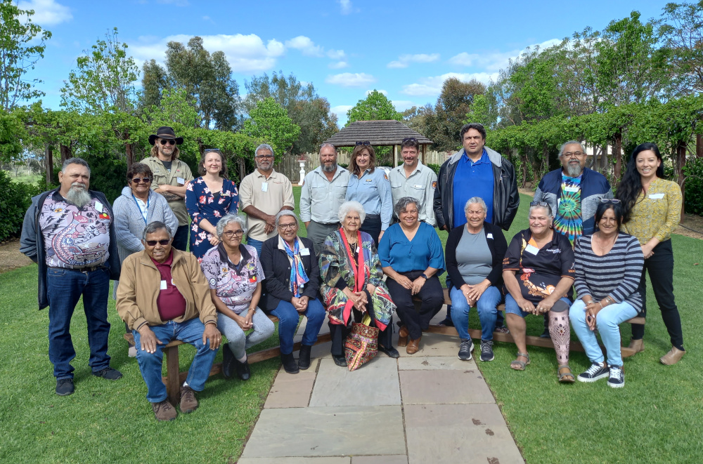 Group shot of 20 people. First row is sitting, and the second row is standing behind them.