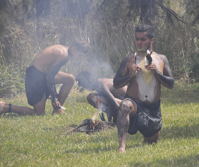 Clontarf dancers perform the Ibis Dance in traditional attire, celebrating Aboriginal culture through movement and song. The dancers, wearing body paint and feathers, convey stories and connections to nature, highlighting the role of dance in cultural expression and preservation.