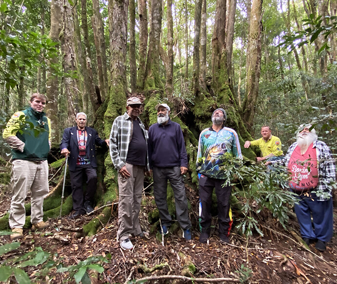 (Left to right) Adam Webb, Uncle Cecil Briggs, Uncle Gary Williams, Uncle Tom Briggs, Hector, Andy Winter and Uncle Brian Flanders with a majestic Antarctic Beech tree