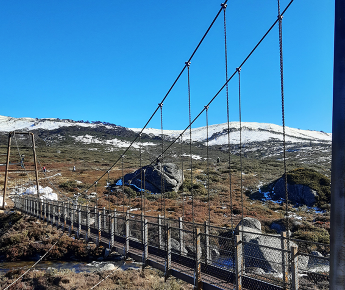 A view of Spencers Creek Bridge, with a backdrop of snow-capped Mt Twynam and the Main Range.