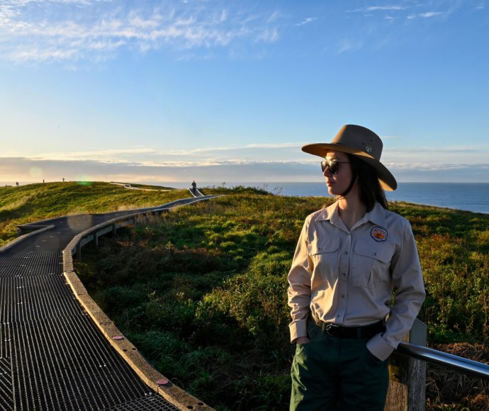 A National Parks and Wildlife Service (NPWS) ranger standing on a walkway at Muttonbird Island Nature Reserve in Coffs Harbour