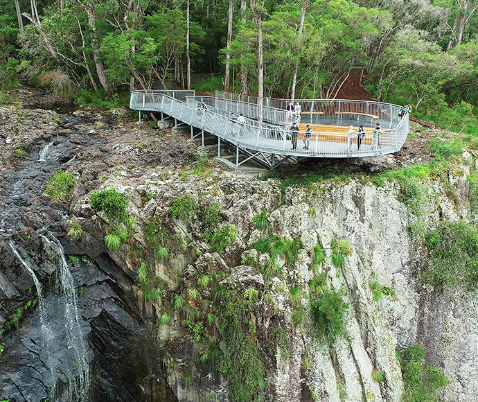 Updates on the Tweed Byron Hinterland Trails project as of December 2021, detailing new facilities at Minyon Falls, including a new lookout, picnic area, and improved accessibility features.