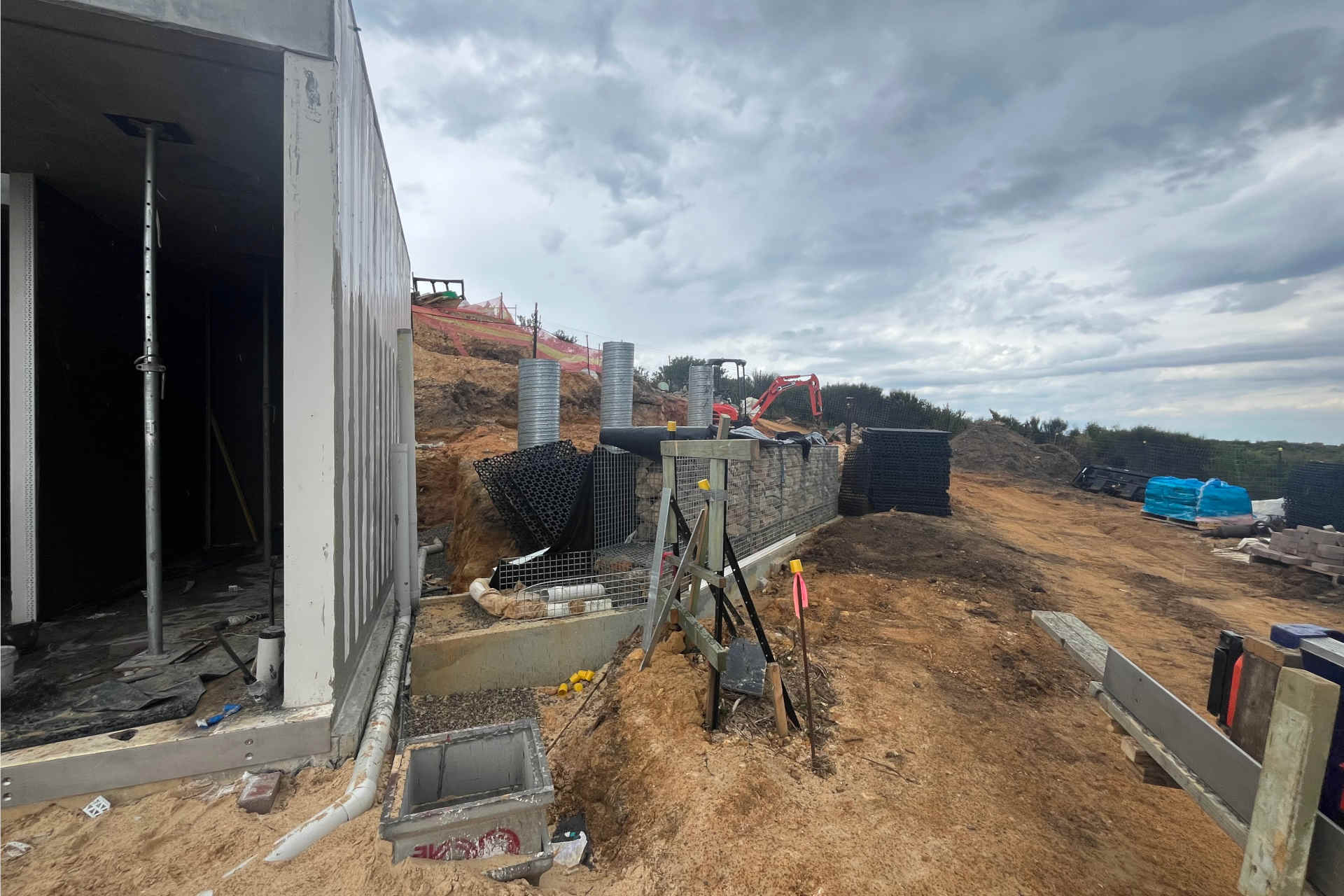 Construction materials on a hillside under a cloudy overcast sky