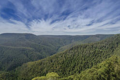 A breathtaking view of Barrington Tops National Park, showcasing a lush, mountainous landscape under a clear blue sky.